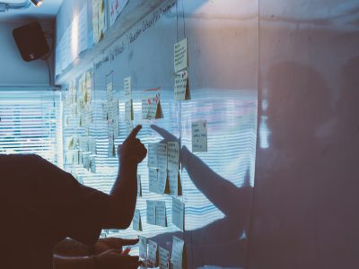 Wall of sticky notes, man pointing